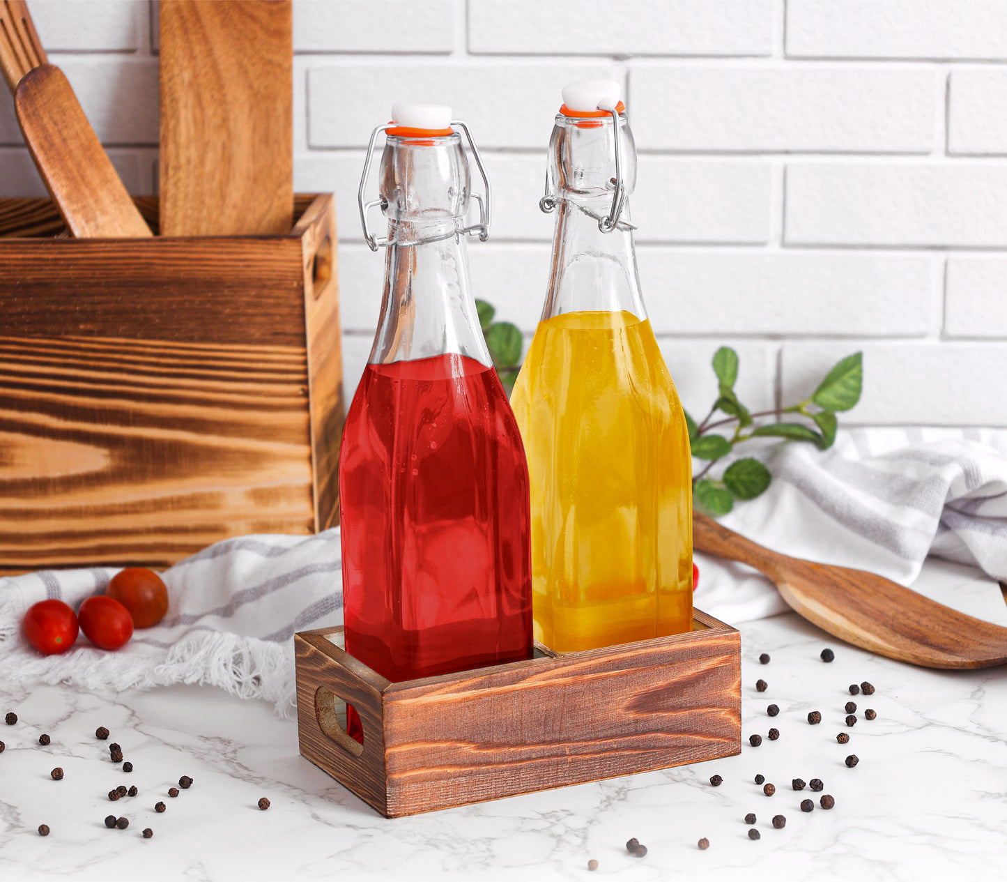 Two glass bottles with red and orange liquids on a wooden stand against a white tiled wall.