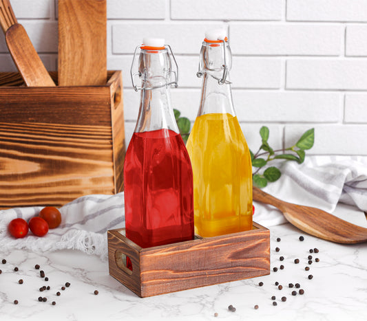 Two glass bottles with red and orange liquids on a wooden stand against a white tiled wall.
